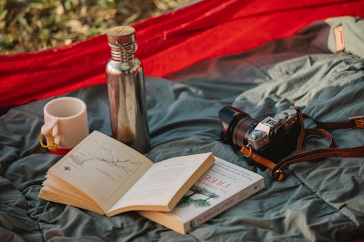 A peaceful outdoor camping scene with a camera, books, and mug in a tent, perfect for relaxation